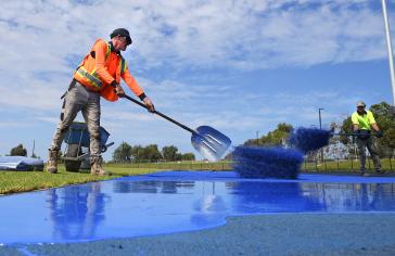 ADELAIDE, AUSTRALIA - JANUARY 27: Workers lay the blue recycled rubber during the Bridgestone Athletic Track Pour For TLA on January 27, 2021 in Adelaide, Australia. (Photo by Mark Brake/Getty Images)