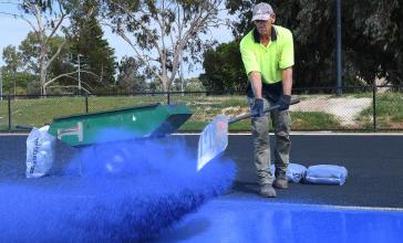 ADELAIDE, AUSTRALIA - JANUARY 27: Workers lay the blue recycled rubber during the Bridgestone Athletic Track Pour For TLA on January 27, 2021 in Adelaide, Australia. (Photo by Mark Brake/Getty Images)